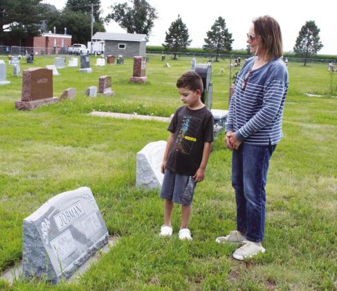 Theresa Holley explains the grave of her great-grandparents, John and Alma Jobman, to her grandson Mason Howard. Theresa now lives in the home that John’s father built 120 years ago, and Mason is the sixth generation to live on the farm. (Leader photo by Ellen Mortensen)