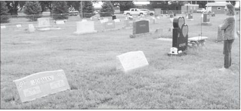 Theresa Holley stands in front of the grave markers for her mom (Donna Kenning), grandparents (Harvey and Irene Lutjemeyer), and great-grandparents (Alma and John Jobman). All of the generations are buried at Zion Lutheran Church Cemetery north of Gothenburg. (Leader photo by Ellen Mortensen)