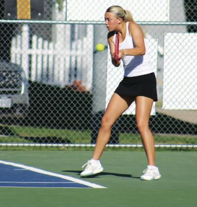 Zoe Beveridge squares up for the return in her singles match against Chandler Haarberg of Kearney Catholic. (Leader photos by Megan Aden)