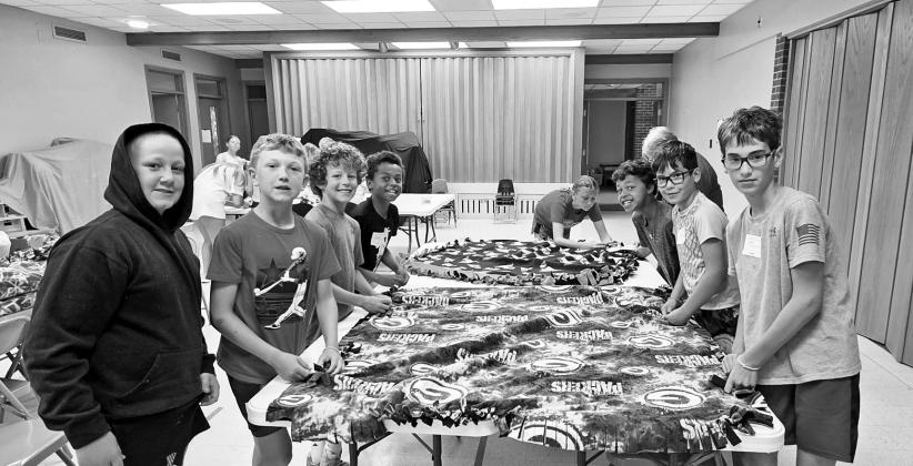 One of the activities at the Zion Vacation Bible School this week is making tie throw blankets, which even the bigger kids seemed to enjoy! (Leader photo by Leta Connell)
