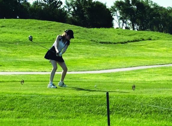 LEFT: Ashlynn Hoffman gets a big swing in the first golf meet of the 2026 season last week, hosted by Kearney Catholic. RIGHT: Amelia Haas is completely focused as she prepares for her swing at the Lady Swedes’ opening golf meet of the season on Aug. 27. (Photos courtesy Tara Foster)