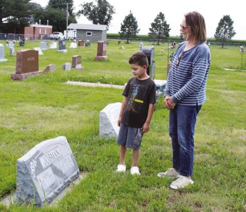 Theresa Holley explains the grave of her great-grandparents, John and Alma Jobman, to her grandson Mason Howard. Theresa now lives in the home that John’s father built 120 years ago, and Mason is the sixth generation to live on the farm. (Leader photo by Ellen Mortensen)