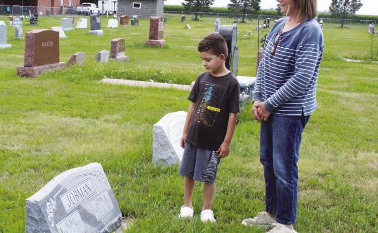Theresa Holley explains the grave of her great-grandparents, John and Alma Jobman, to her grandson Mason Howard. Theresa now lives in the home that John’s father built 120 years ago, and Mason is the sixth generation to live on the farm. (Leader photo by Ellen Mortensen)