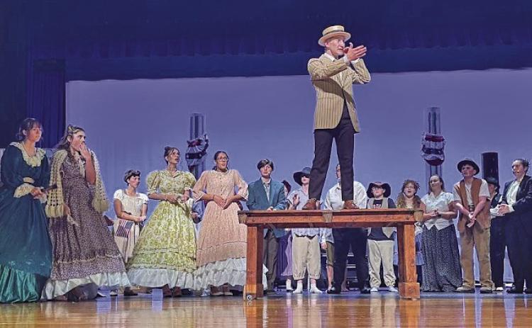 Prof. Harold Hill (Carter Kincheloe) tries to rile up the townspeople in an effort to dupe them into buying into his scam.