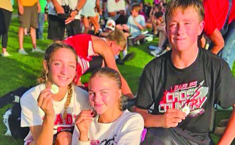 Brady cross country medalists Paisley Connelly, Zoe Johnson and Gus Barnes show off their medals following the Arapahoe Invite on Sept. 17. Connelly placed first, while Johnson and Barnes each finished third. (Photo courtesy of Brady Public Schools)
