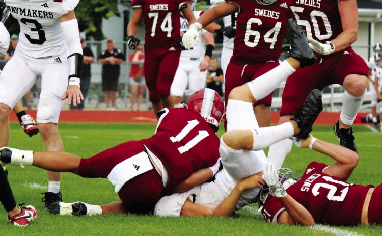 Tristan Koch (#21) landed underneath the Cozad ball carrier as he made the stop, assisted by Braden Ehlers (#11).