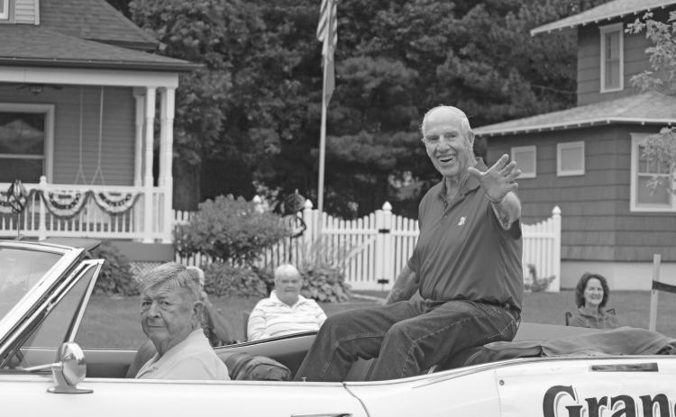 2026 Harvest Festival Grand Marshal Larry Franzen waves as he passes by in Saturday morning’s parade.