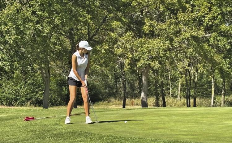 Lily Sics watches the ball as she shoots a putt during the district golf meet in Lexington on Oct. 5. (Photos courtesy Tara Foster)