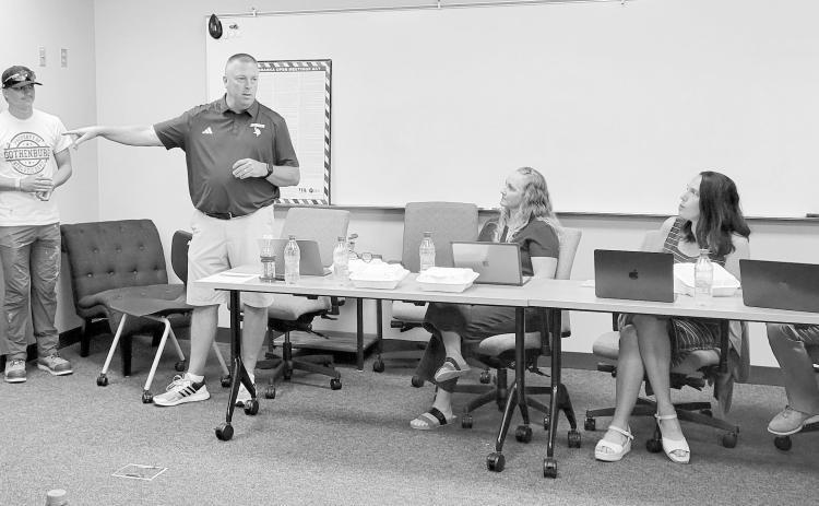 Gothenburg AD Marc Mroczek, standing, recognized Bryson Neels, left, and Jax Rickertsen as state track medalists during the July 13 school board meeting. Also pictured, from left, are school administrators Maggie Tiller, Tomye McKenna, and Seth Ryker. (Leader photo by Ellen Mortensen)