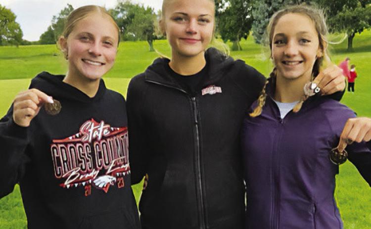 Brady cross country medalists Violet Gentry, Zoe Johnson and Paisley Connelly pose following the Broken Bow Invite on Sept. 12. Johnson placed sixth, Gentry finished 15th and Connelly placed eighth in the junior high race. (Photo courtesy Brady Public Schools)