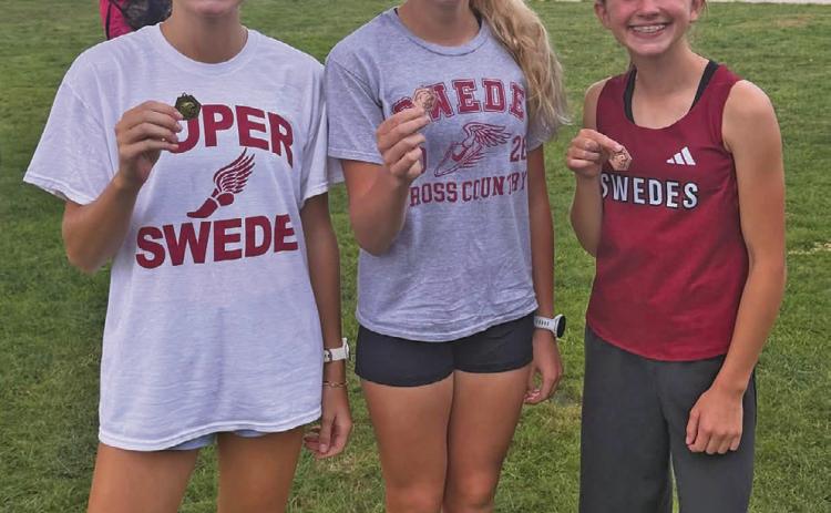 Running their way to the medal stand for the Gothenburg women’s cross country team last week were, from left: Scout Bell, 1st place; Brooklyn Reiman, 14th place; and Cassidy Reiman, 4th place.