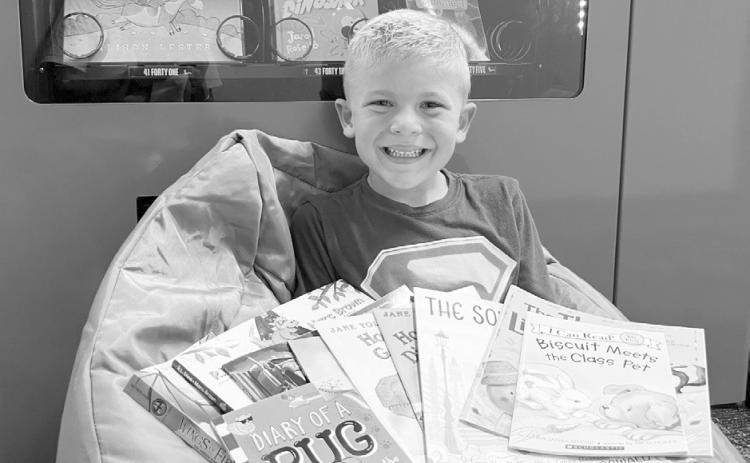 Dudley Elementary gives a huge shoutout to Baylor Haake for completing the 1,000 Books Before The End of Kindergarten Challenge. With help from his mom, dad, and big sister Harper, Baylor read 1,000 books - and especially loved looking at all the pictures along the way. To celebrate, he picked out 10 new books from Mrs. Floyd's office, including one from the TeamMates Vending Machine. (Photo courtesy Dudley Elementary)